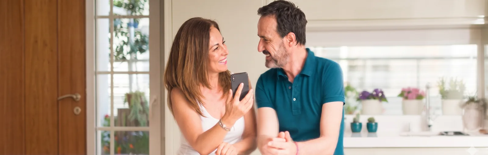Trousseau de clés posé sur un carnet en cuir, à côté d'une tasse de café et d'un téléphone affichant l'app Logio